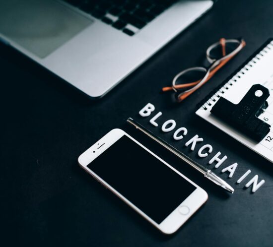 Flat lay of a modern digital workspace with blockchain theme, featuring a smartphone and calendar.