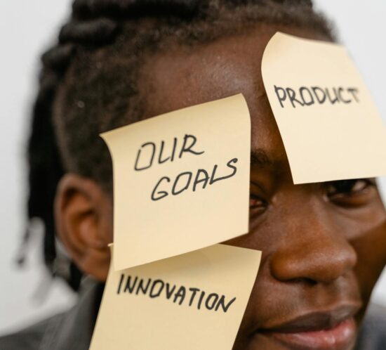 Close-up of person with sticky notes on forehead, symbolizing creative brainstorming and innovation.